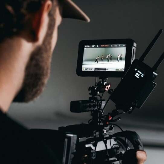 Dieci libri per capire il cinema (e chi lo fa). Foto di Kyle Loftus: https://www.pexels.com/it-it/foto/uomo-in-camicia-nera-che-tiene-videocamera-5022805/