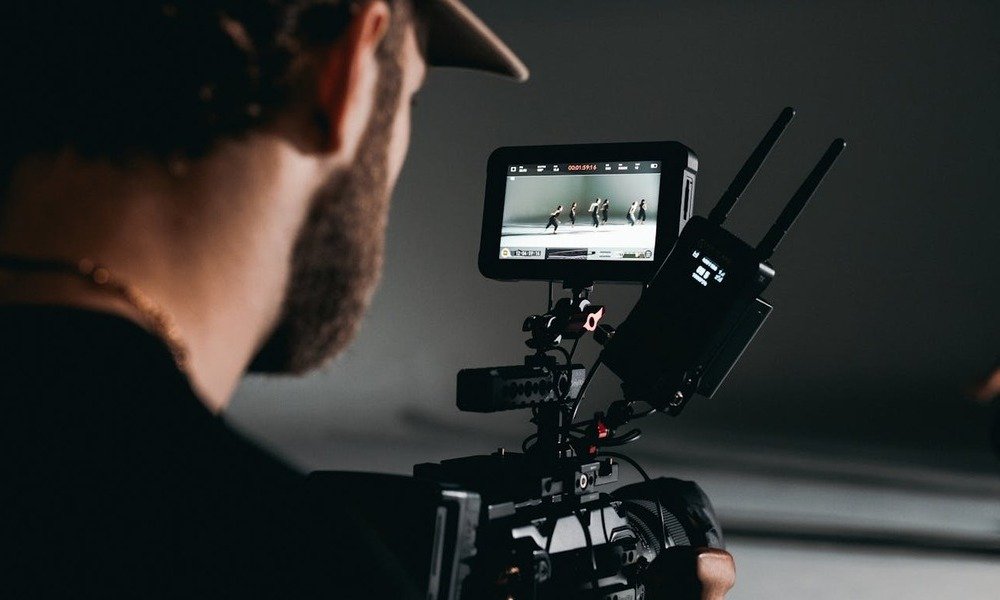 Dieci libri per capire il cinema (e chi lo fa). Foto di Kyle Loftus: https://www.pexels.com/it-it/foto/uomo-in-camicia-nera-che-tiene-videocamera-5022805/